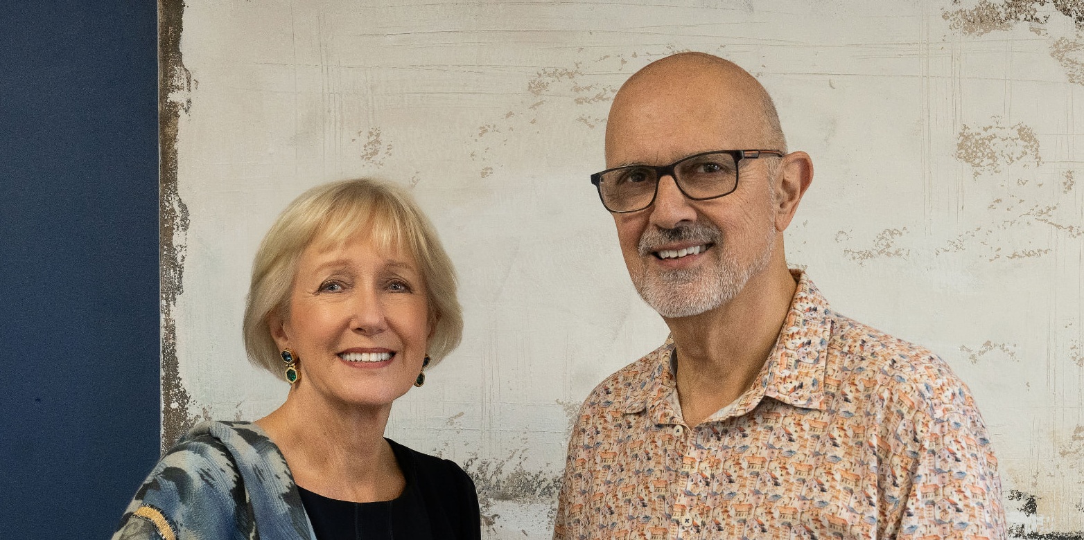 Julie and Mike Matthews, Founders of Duet, standing together for a portrait indoors